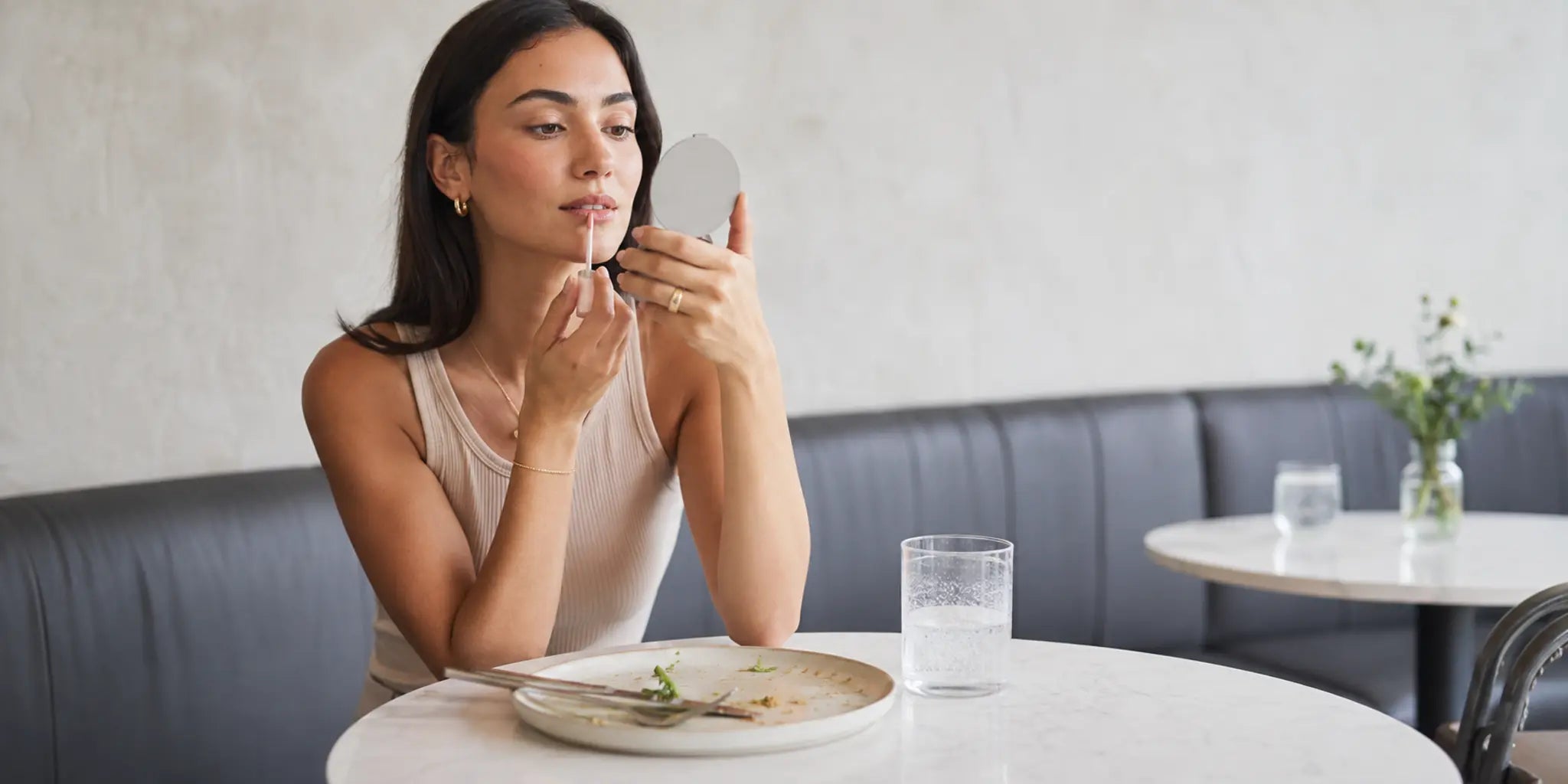 Woman checking her lips at a cafe after a meal