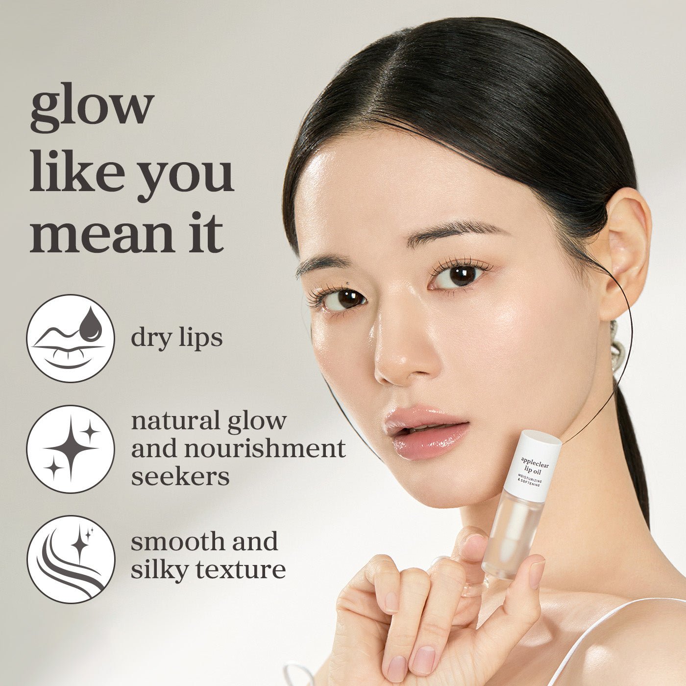 Model holding Appleclear lip oil highlighting natural glow, nourishment, and smooth lip care.