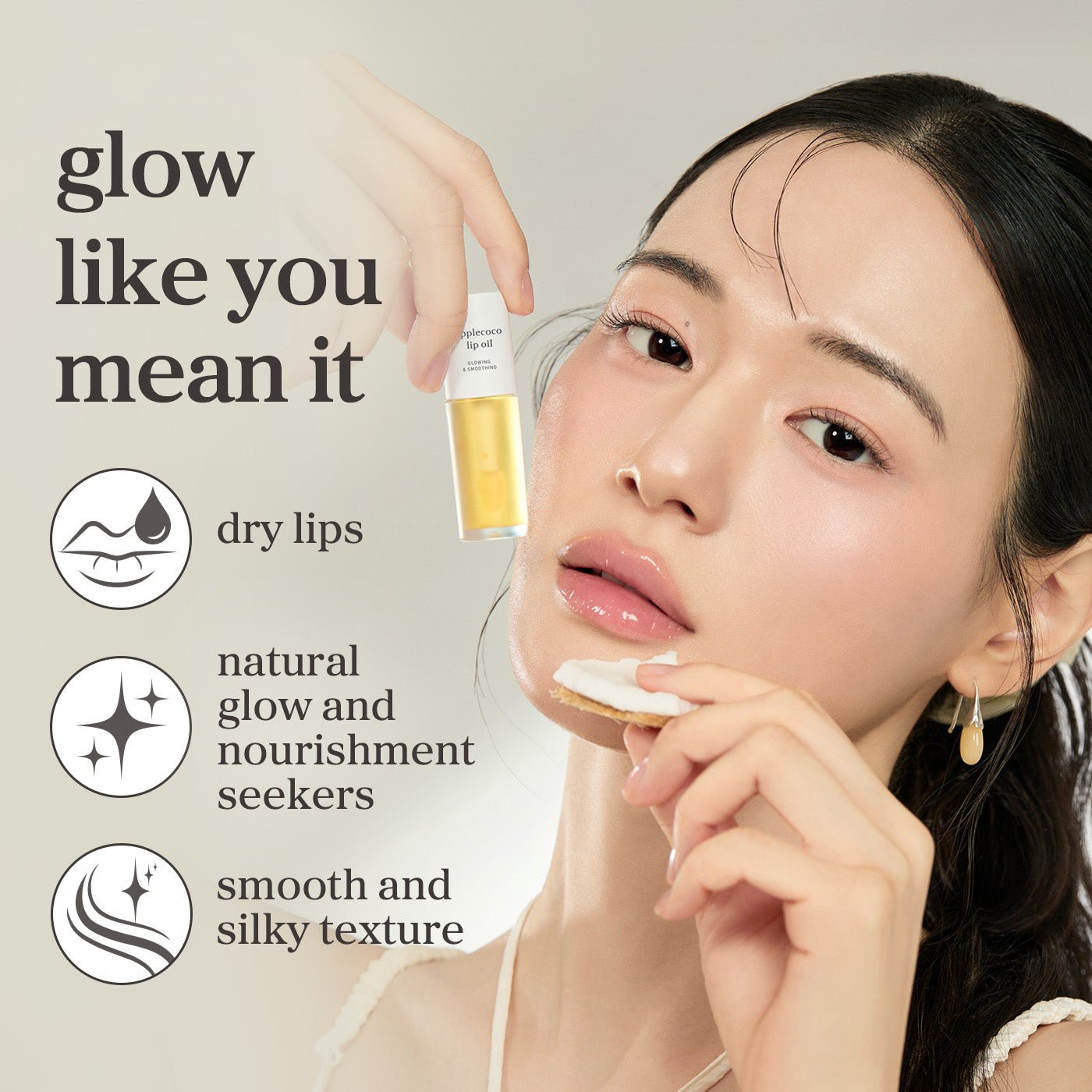 Model holding nooni applecoco lip oil highlighting glossy lips, natural glow, and a smooth, silky finish.