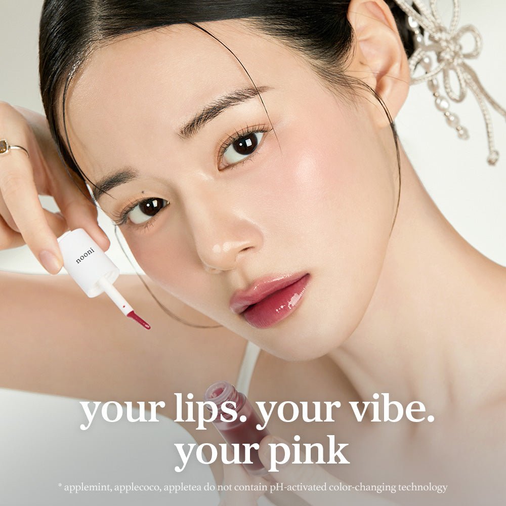 Model applying nooni apple mulberry lip oil with glossy lips and lip applicator close up.