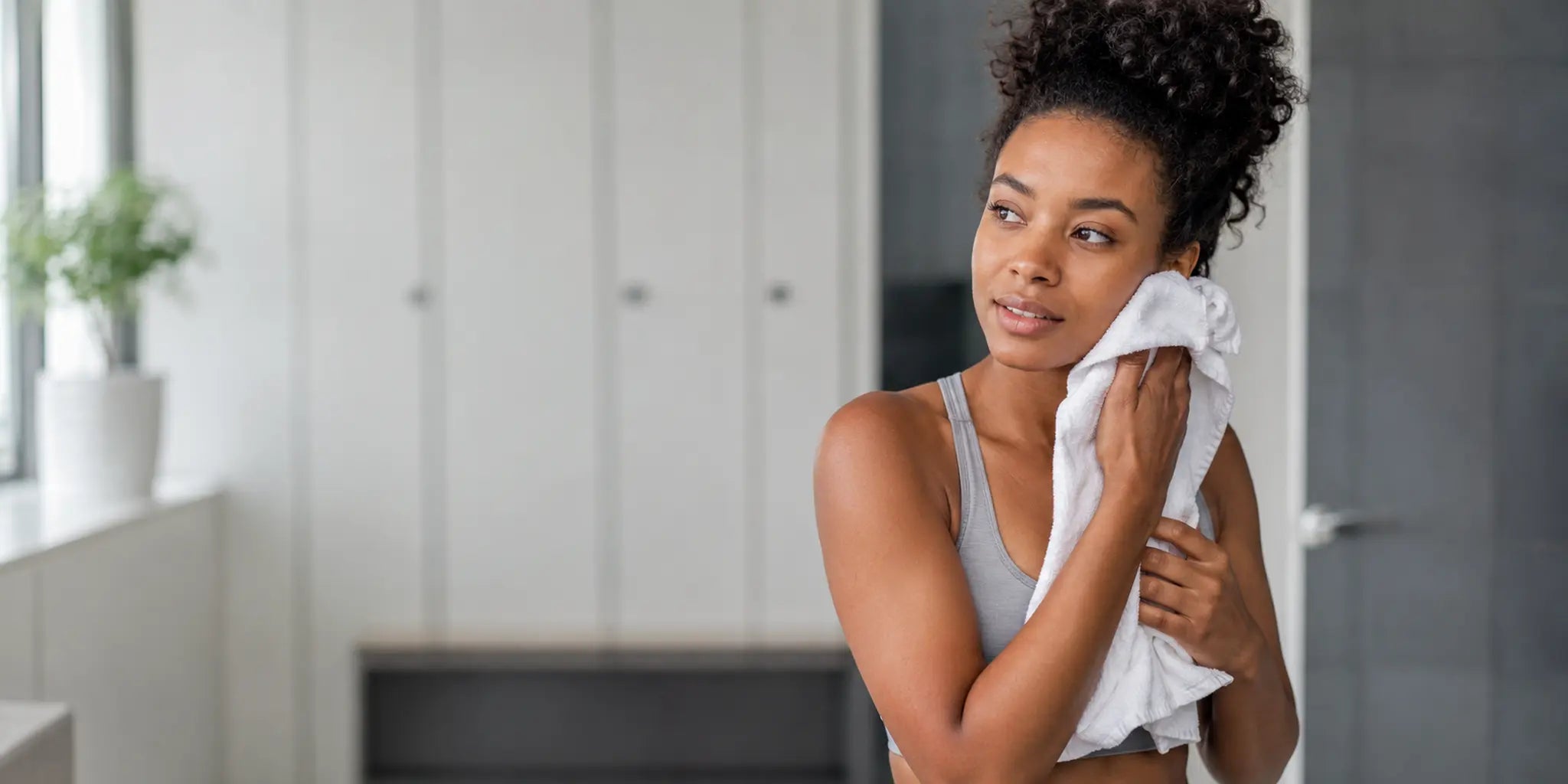 Woman patting her face with a clean towel after a workout