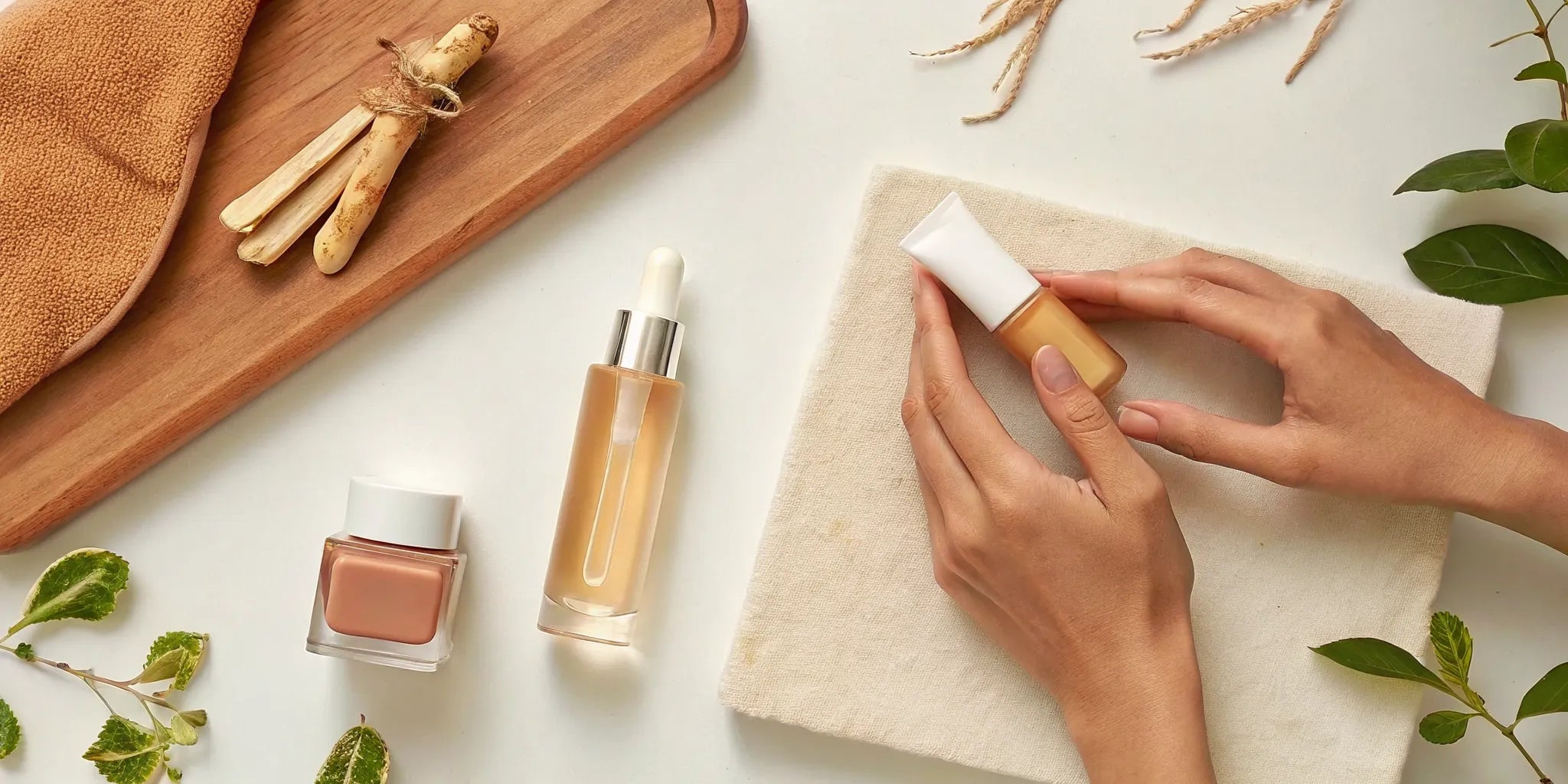 Flat lay of vegan K-beauty skincare products with lip oil, moisturizer, and green botanicals on a clean white surface