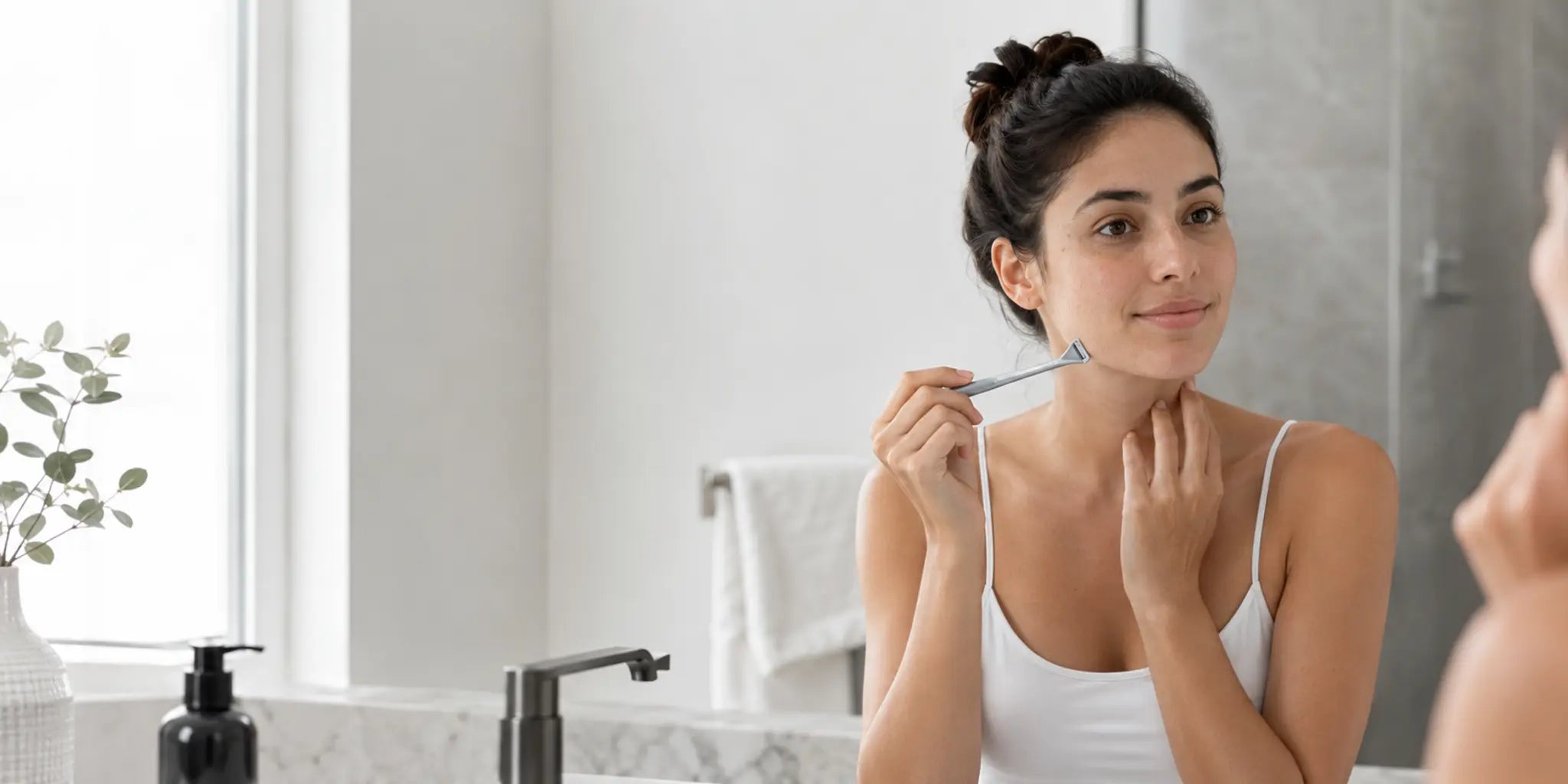 Woman preparing for a gentle facial shave at a clean bathroom vanity