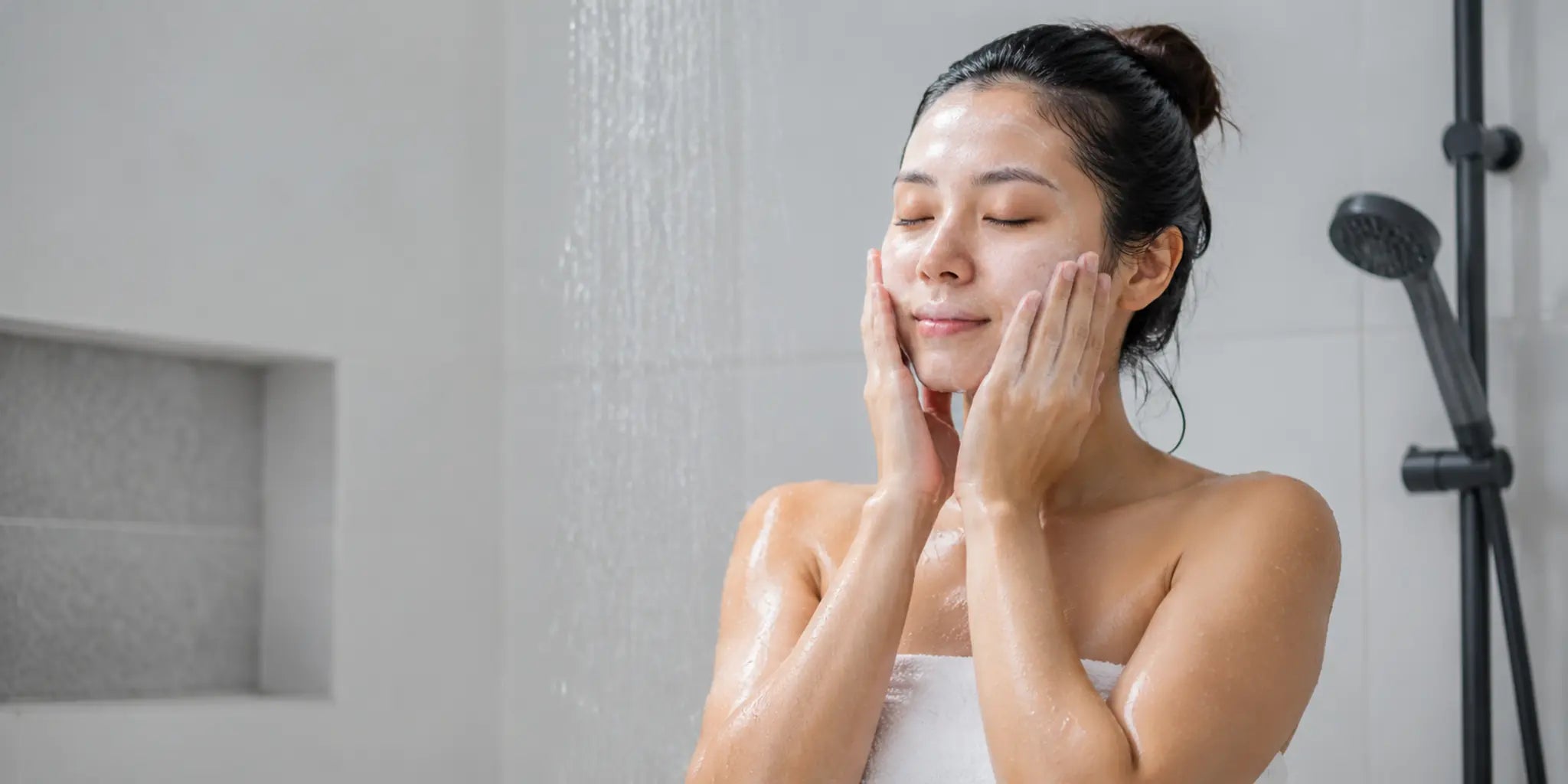 Woman gently washing her face in a lukewarm shower