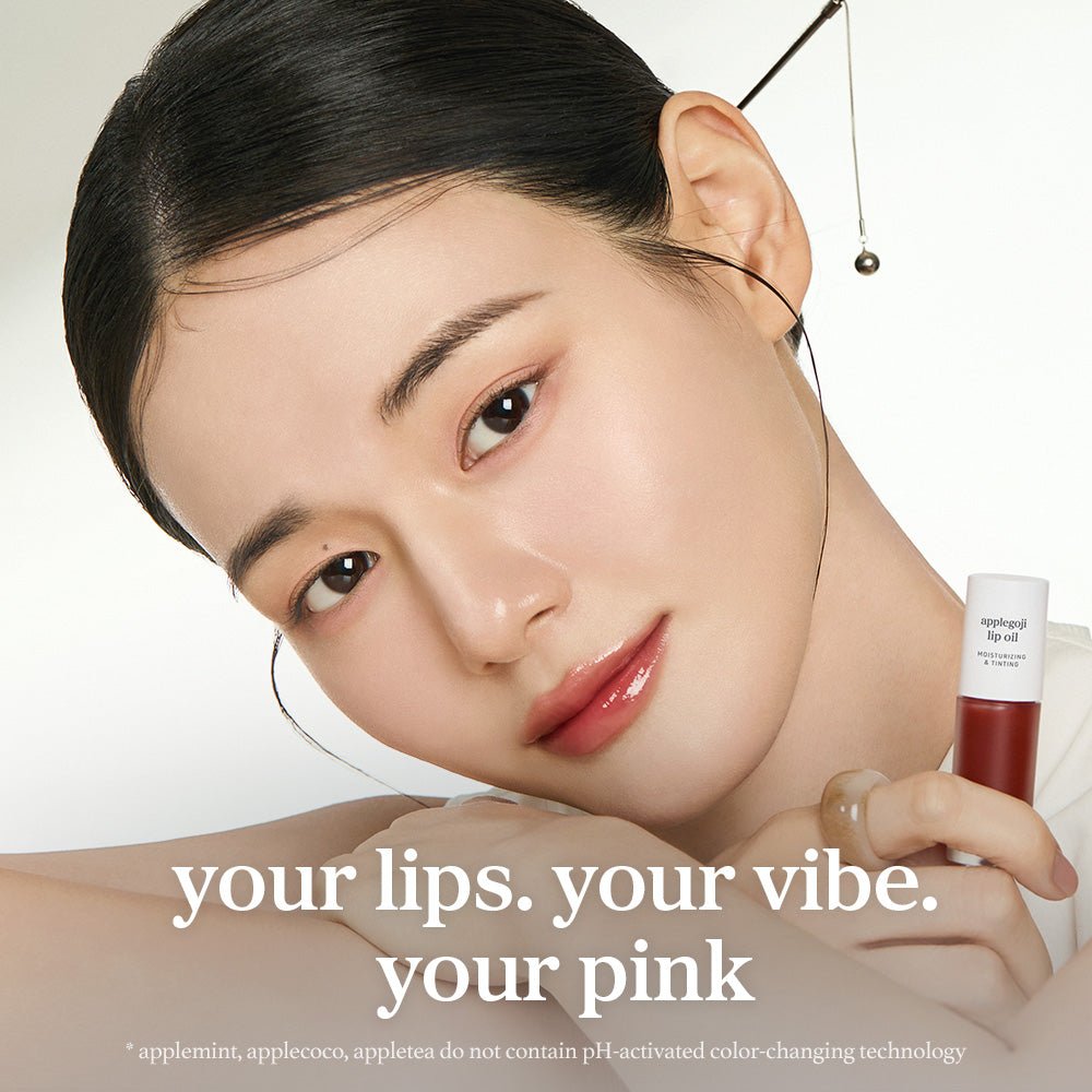 Model applying nooni applegoji lip oil with glossy lips and lip applicator close up.